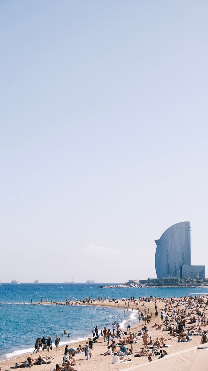 “Crowded beach scene in Barcelona, Spain with clear skies and a view of the ocean.” by Şeyma A, via Pexels, used under the Pexels License.